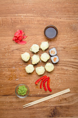 Unusual sushi rolls on a wooden table. Ukrainian sushi rolls with baked cheese and crabs