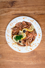 Appetizing shrimps in soy sauce on a white dish. Shrimps with olives and lemon. Restaurant seafood dish. Tasty diet food