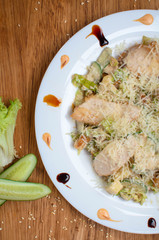 Chicken breast and cheese salad with cucumber and lettuce. Restaurant dish on a beautiful plate. Delicious, healthy lunch