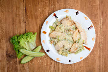 Chicken breast and cheese salad with cucumber and lettuce. Restaurant dish on a beautiful plate. Delicious, healthy lunch