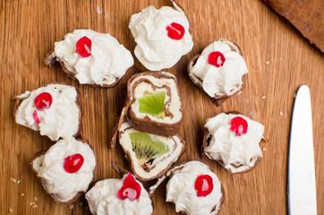 Sweet rolls made of pancakes filled with fruit and covered with cream and jam. Sweet breakfast Delicious dessert