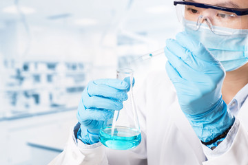 Fototapeta premium Laboratory beaker in analyst's hand in plastic glove