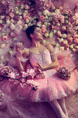Blossoming soul. Top view of beautiful young woman in pink ballet tutu surrounded by flowers. Spring mood and tenderness in coral light. Art photo. Concept of spring, blossom and nature's awakening.