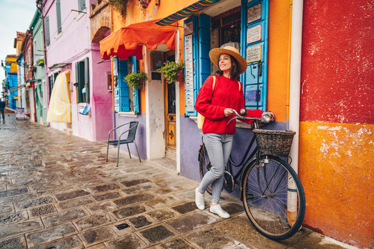 Fototapeta Smiling girl with a bike in Italy