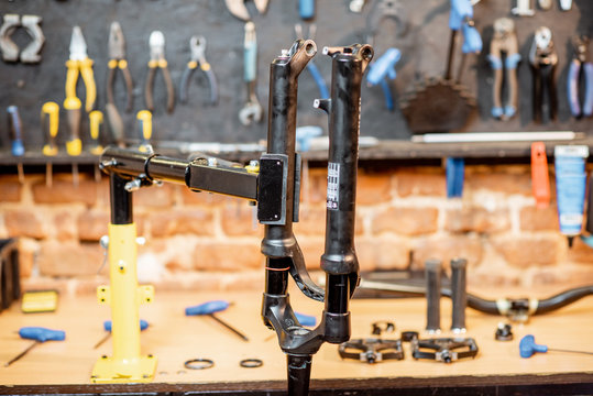 Bicycle fork during the repairing process hanging on a stand in the bicycle workshop