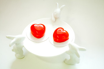 heart-shaped cake red on a white plate with rabbits isolated on a white background