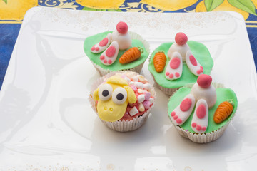 Detail of funny Eastern muffins with rabbit character hiding in the ground and sheep