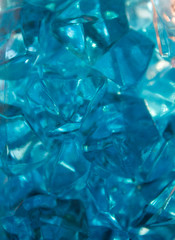 Blue crystals of glass with highlights of light on them, blur, close-up, abstraction.