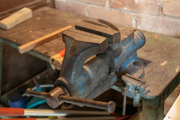 rusty blue bench vice in a rural workshop