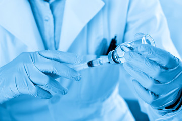 Laboratory beaker in analyst's hand in plastic glove