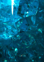 Blue crystals of glass with highlights of light on them, blur, close-up, abstraction.