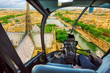 Helicopter flying on the roof of Notre Dame church spotting its spire, in Paris panorama, French capital, Europe. Scenic flight over Paris cityscape.