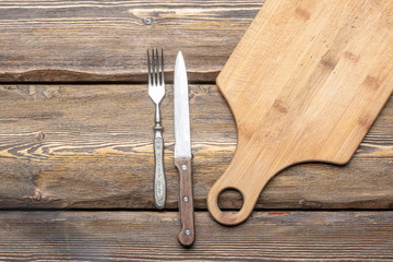 utensils with square candle and vintage cutlery on wooden background, top view 