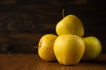 Yellow apple on the wooden vintage background