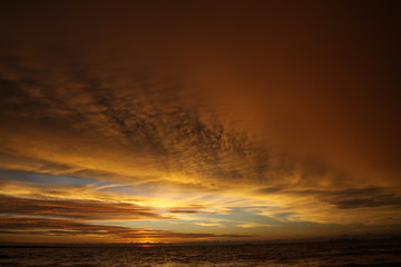 Fototapeta na wymiar Sunset after heavy rain with arcus shelf storm clouds and stones in the ocean on tropical island Ko Lanta, Thailand