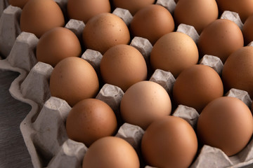 a lot of fresh red eggs in a protective cardboard tray, short focus