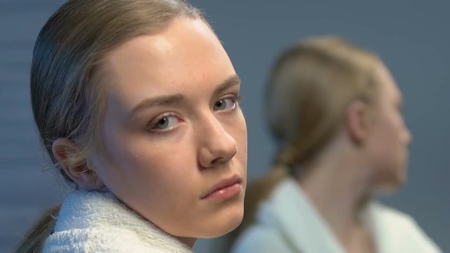 Depressed teenager girl turning to camera, bullying problems in awkward age
