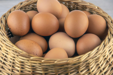 wicker basket with dietary brown eggs, top view, on a wooden table