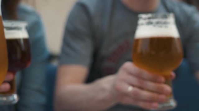 People, leisure, friendship and celebration concept - happy friends drinking draft beer and clinking glasses at outdoor cafe