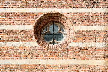 close up brick wall and small round window of Grote Kerk, church in Leerdam, The Netherlands
