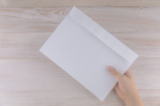 the boy holds an empty envelope with free space for inscriptions