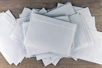 outgoing correspondence: set of blank white envelopes on a wooden desk in the office, toning, blur