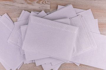 outgoing correspondence: few empty white envelopes on a wooden desk in the office, low contrast