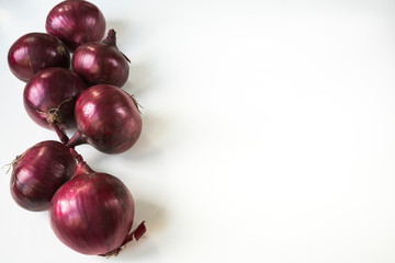 seven red onions against white background, border, copy space