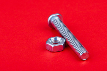 Screw with nut single on red background