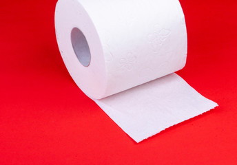 toilet paper roll on red background half unrolled