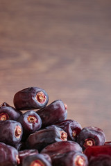 dried dates fruit heap on blurred wooden background vertical orientation copy space