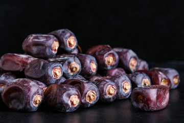 dates fruit heap on black background close up. Ramadan food