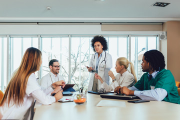 Medical team sitting and discussing at the table in the office.