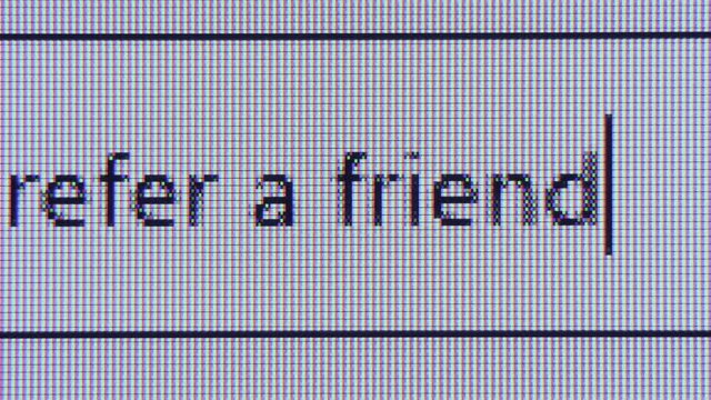 Close up of blinking cursor typing refer a friend in browser search bar. Macro view of internet web page with request engine form