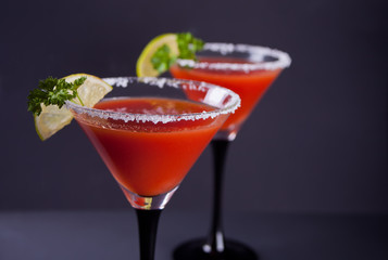 Bloody Mary Cocktail in glasses. Tomato Bloody Mary spicy drink on black background.