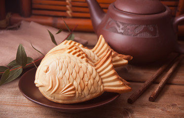 Taiyaki Japanese street food fish-shaped sweet filling waffle on wooden table