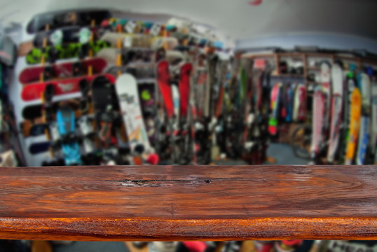 Mockup. Image of sport store with equipment for skiing. Defocused, blurred image. In the foreground is the top of a wooden table, counter.
