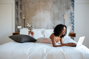 Woman sitting on bed on the computer