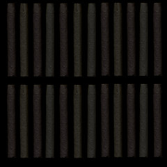 Cigars on a dark background. Cigars in the dark. Background of evenly spaced cigars.