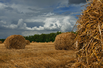 View of straw bales on a background od dark stormy clouds