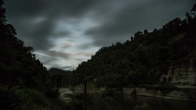 Clouds sky moving fast over Whanganui river in dark evening with stars in New Zealand nature Time lapse