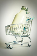 Glass bottle with milk in a shopping cart close-up. Photos in the old retro style