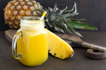 Pineapple juice in a jar with a straw.