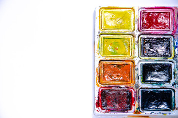 Palette with watercolors and brushes for paints on a white background. Watercolor paints. Brushes. Top and front view