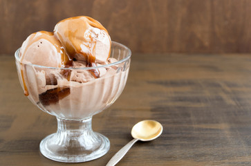 chocolate ice cream in a glass vase. on a wooden background.