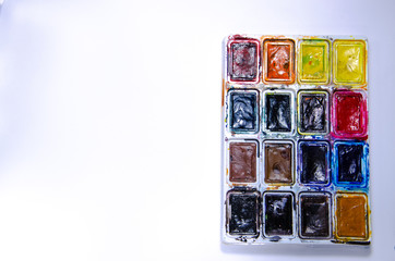 Palette with watercolors and brushes for paints on a white background. Watercolor paints. Brushes. Top and front view