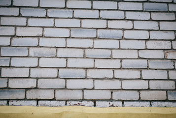 Wall is made from bricks and painted with white color.