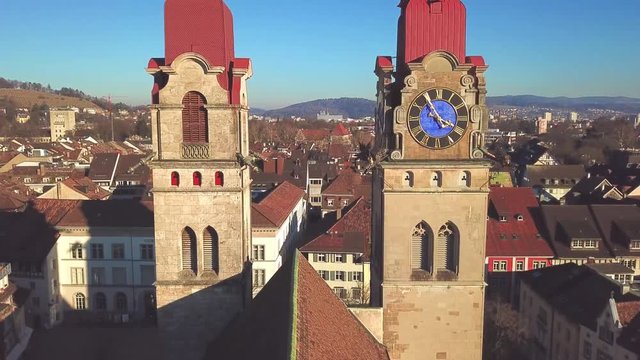 Drone flight with aerial view above church in old town of Winterthur in Switzerland. Tower and building roofs from above. Dynamic, stabilized and smooth shots of European town.