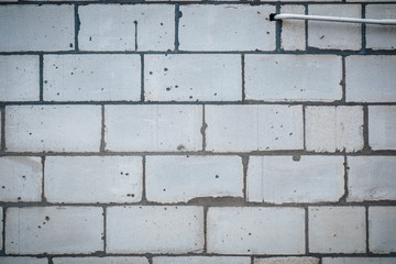 Wall is made from bricks and painted with white color.