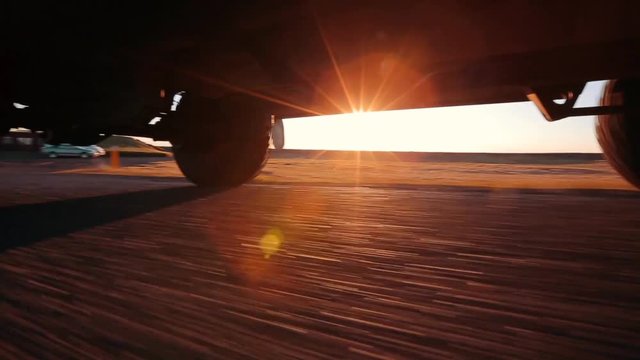 Low angle shot from under a four wheel drive vehicle crossing the black volcanic sand of Sprengisandur in Iceland. Wheels throw up dust in a dramatic adventurous scene of the empty highland desert.